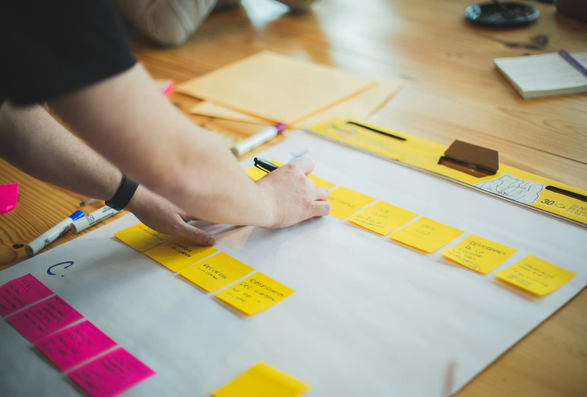 Hands arranging sticky notes during a planning workshop
